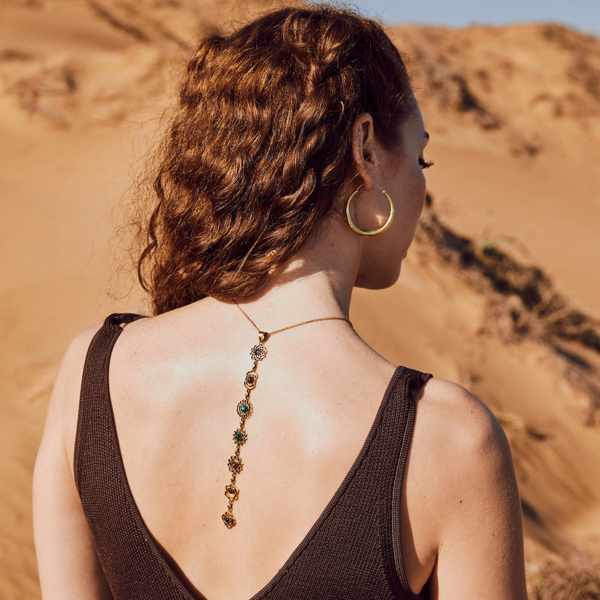 Modelo con pendientes de aro Lia y colgante 7 chakras piedras en oro
