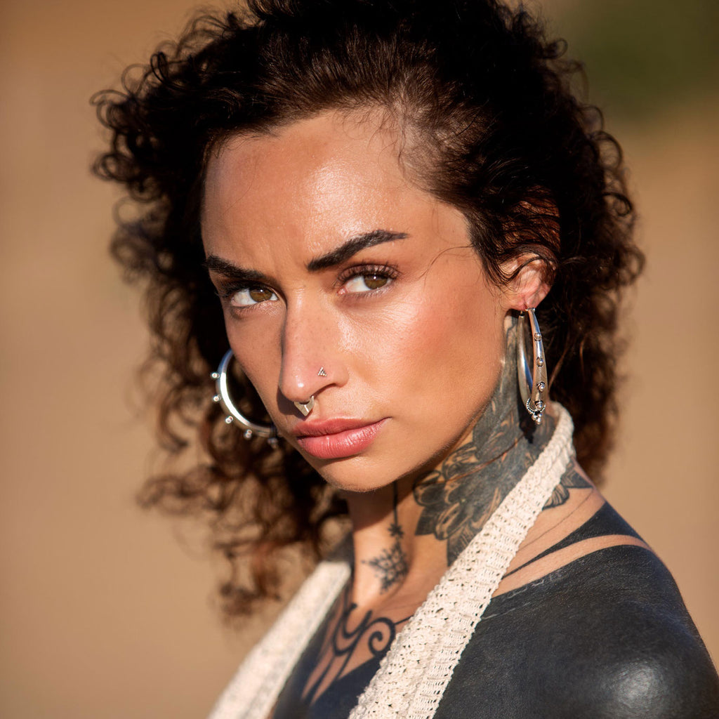 modelo con pendientes de aro Nomad y septum geometric