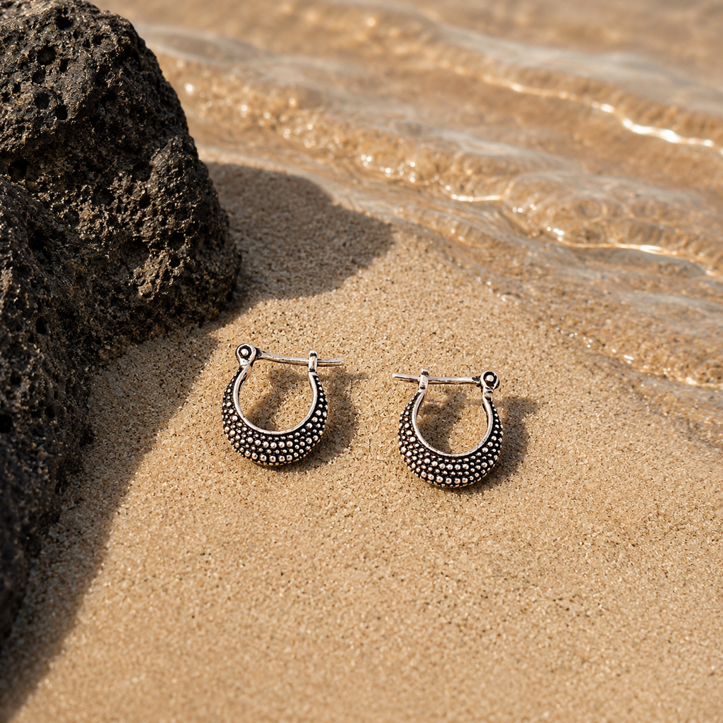pendientes de aro pequeños plata sobre arena de la playa