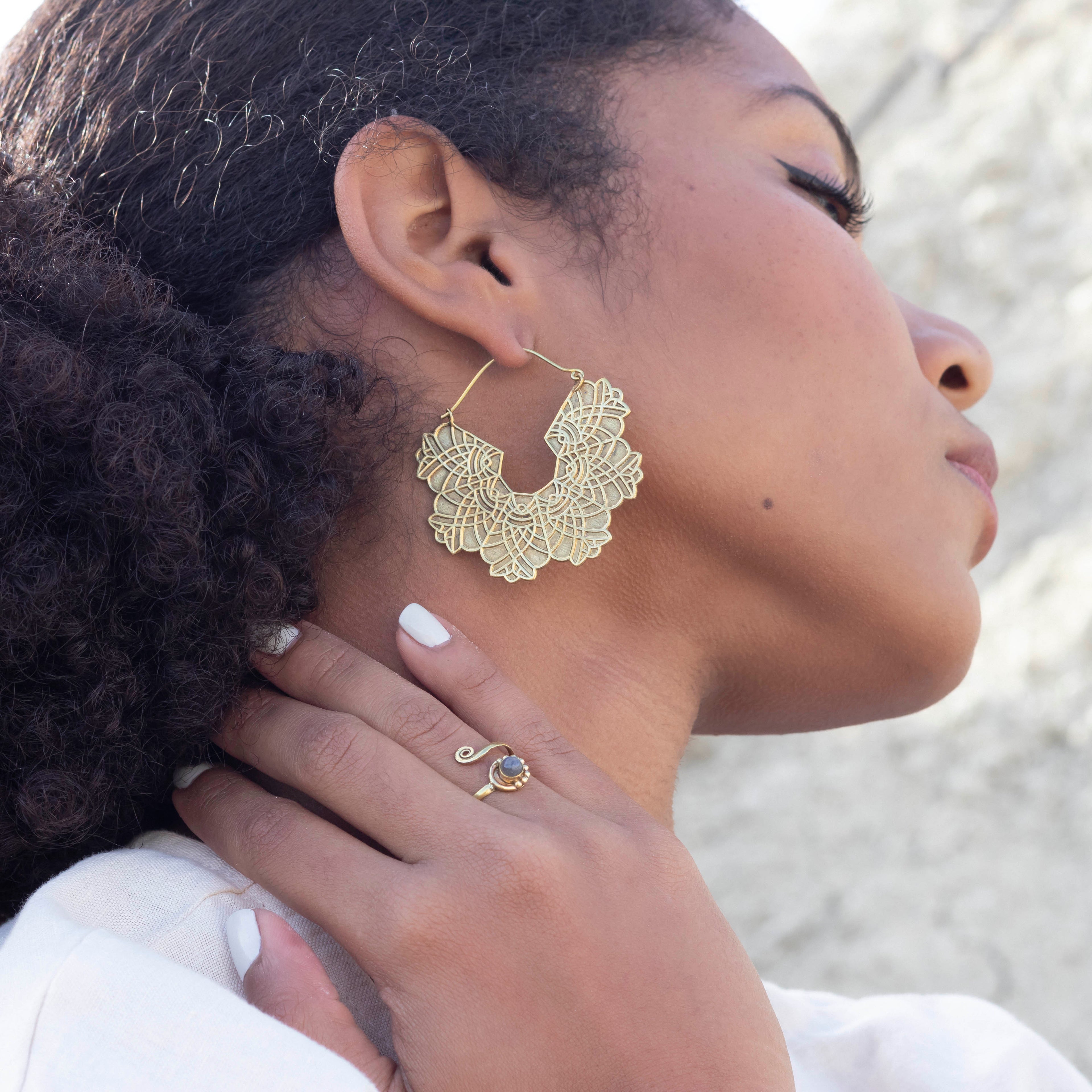 modelo con pendientes Leah dorado y anillo uma