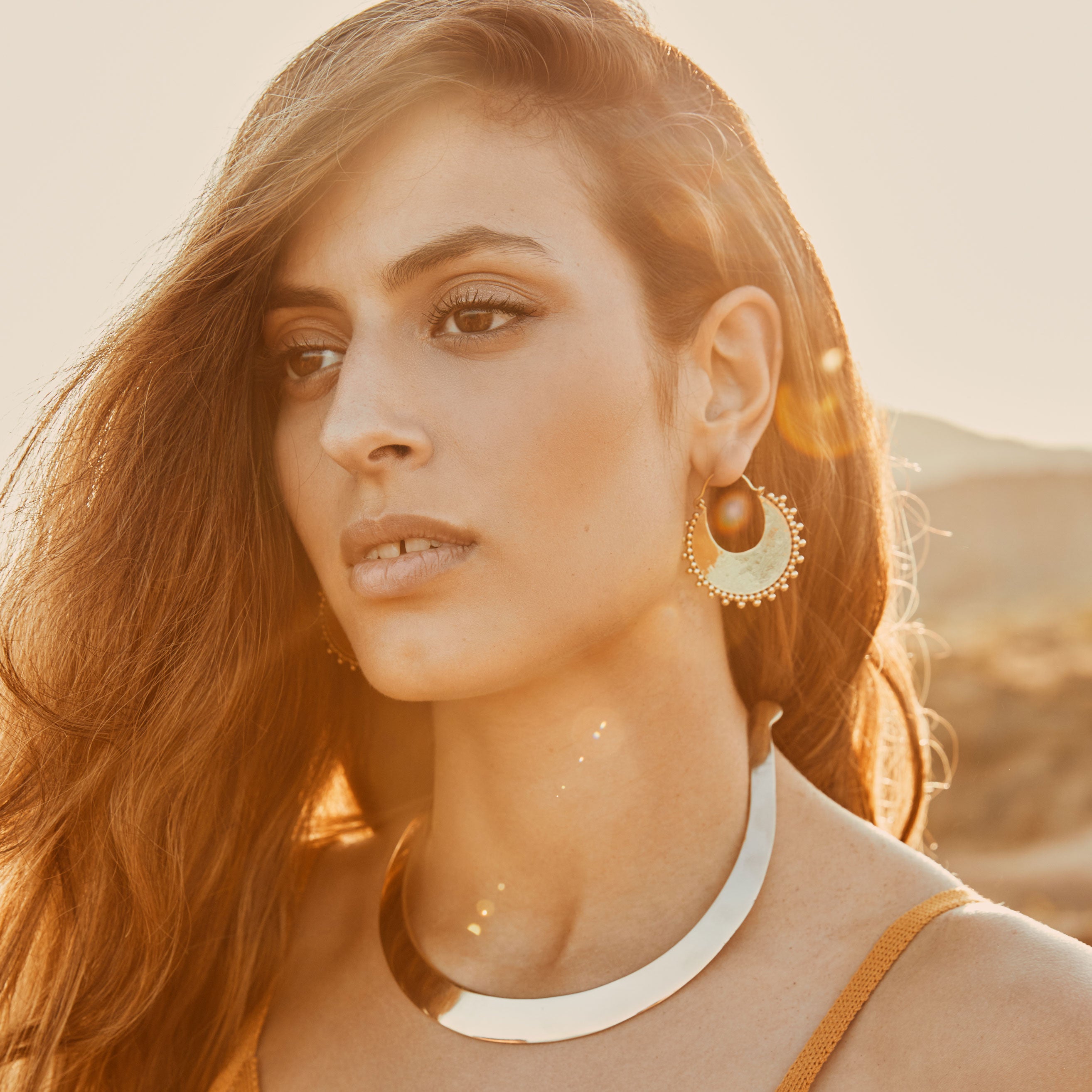 modelo con pendientes aro Nara y choker Zahra dorado