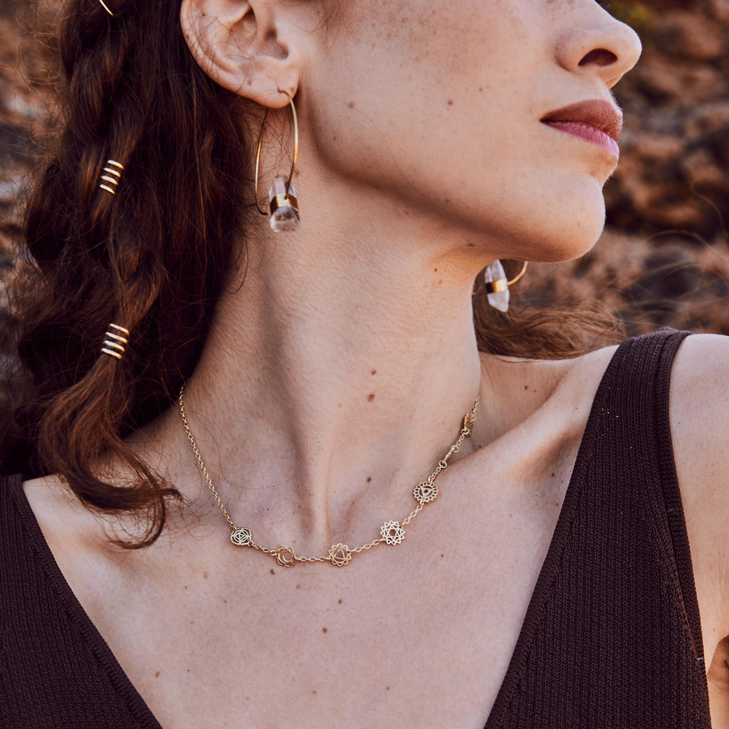 modelo con aros de cuarzo y choker chakras en dorado