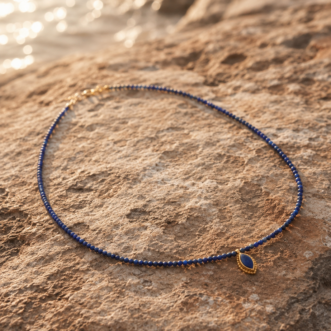 collar lapislazuli y latón sobre roca de la playa