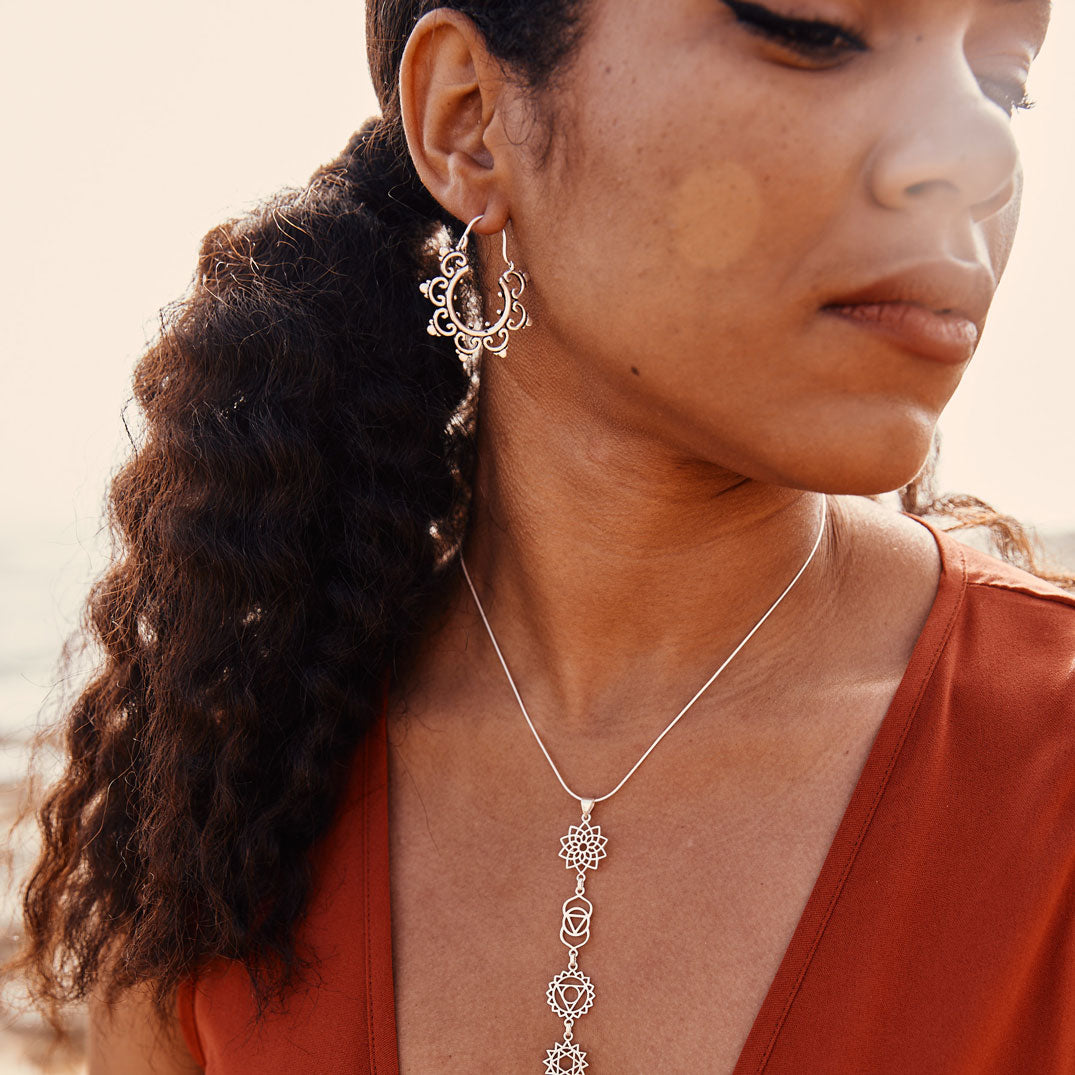 Modelo con pendientes de aro plata iris y colgante 7 chakras plata