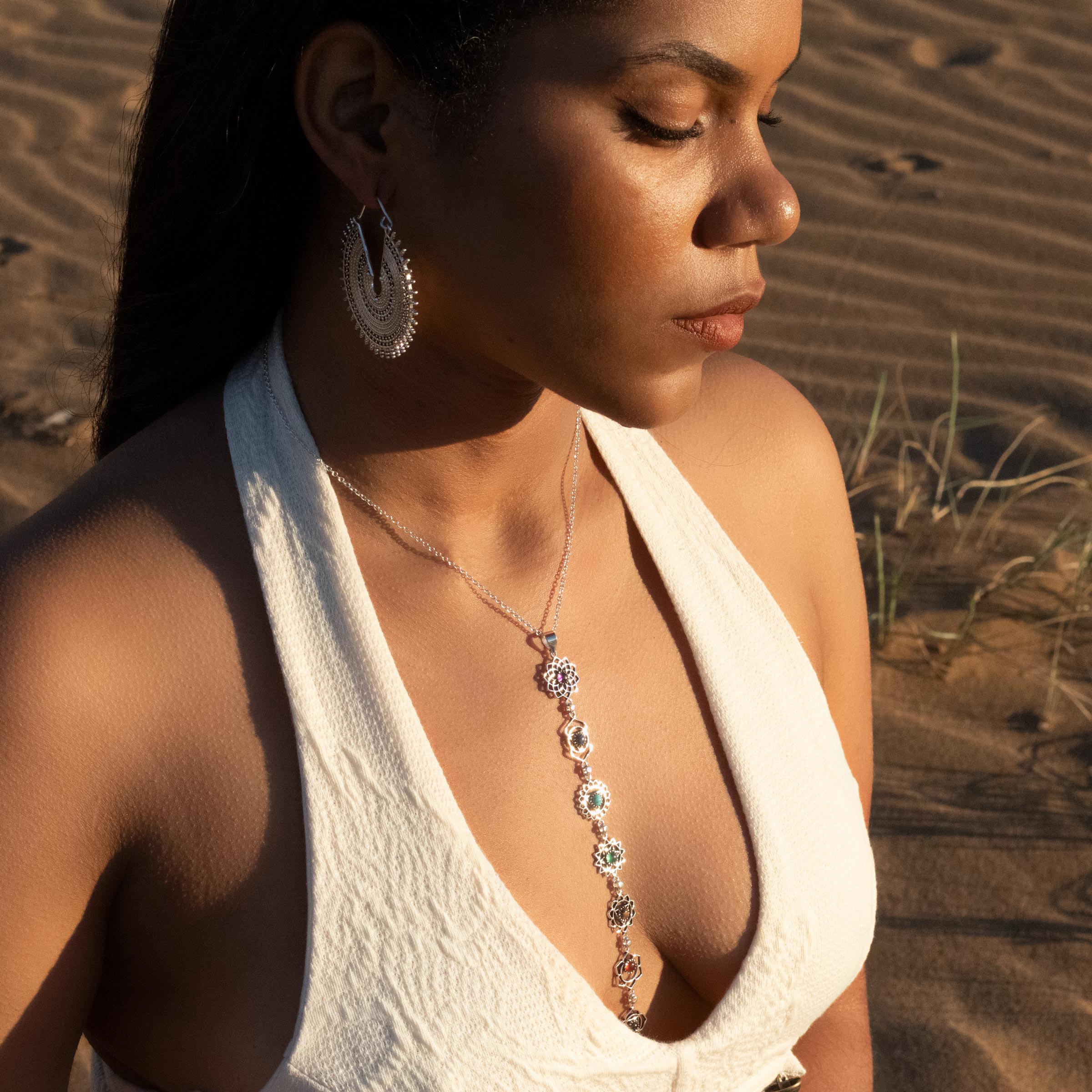 modelo con pendientes Zahra plata y colgante chakras piedras
