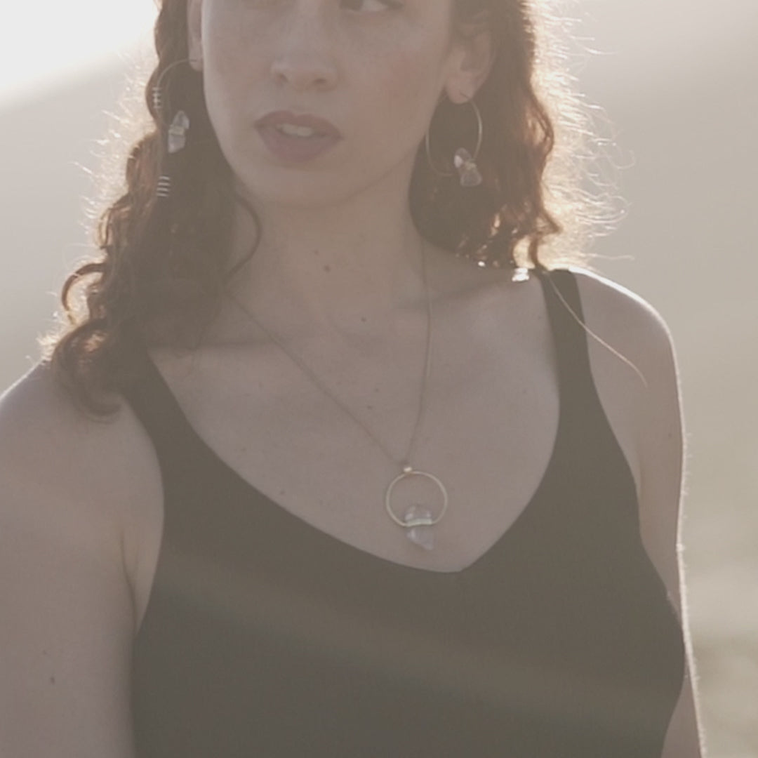 video de modelo con collar y pendientes de cuarzo en dorado