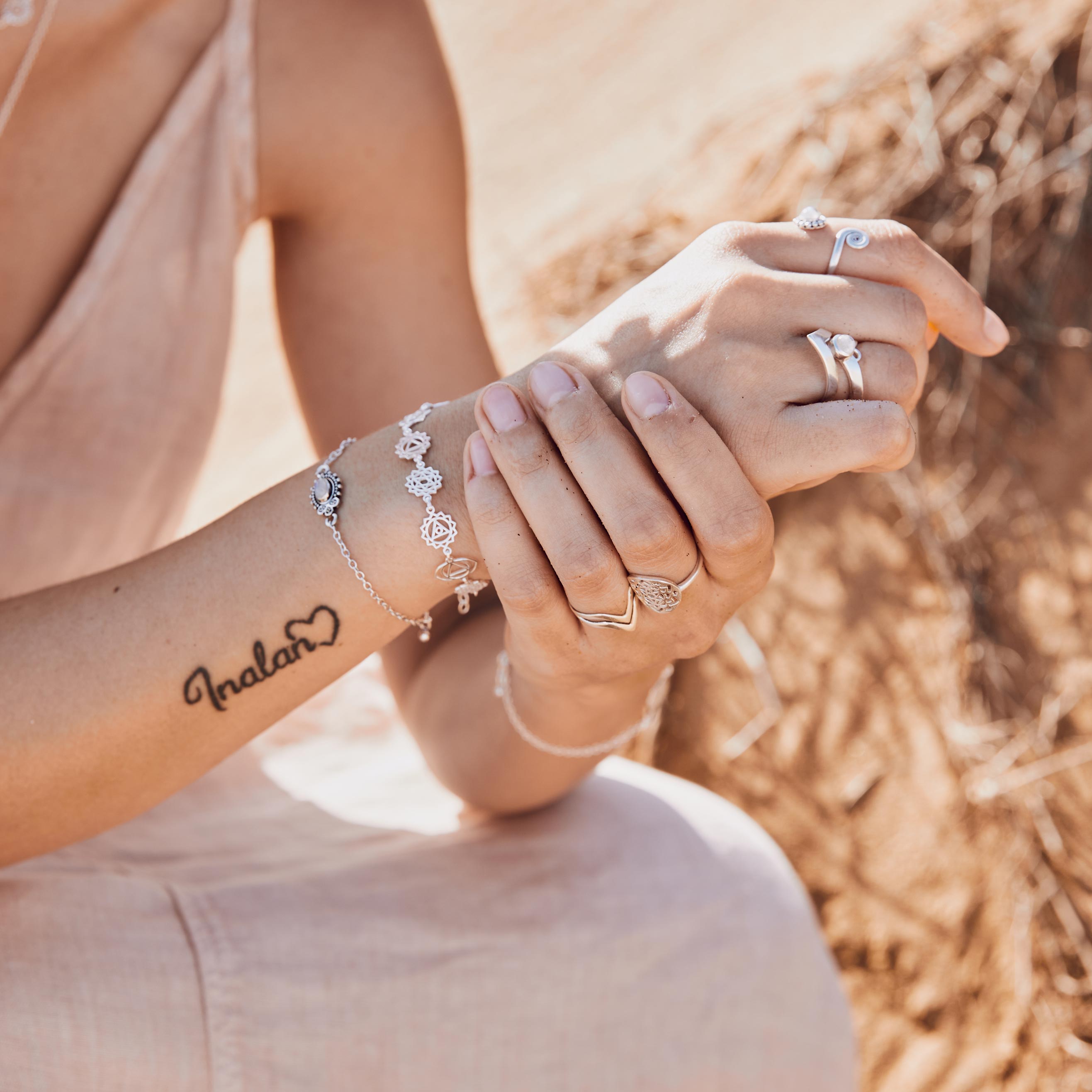 foto de manos con pulsera chakras y anillos plata